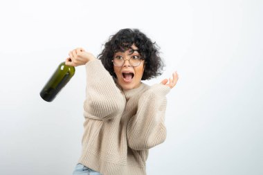 Bir şişe şarapla dans eden kısa saçlı esmer kadınla parti zamanı. Yüksek kalite fotoğraf