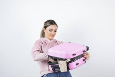 Elbiselerini almak için genç ve güzel bir model valizini açıyor. Yüksek kalite fotoğraf