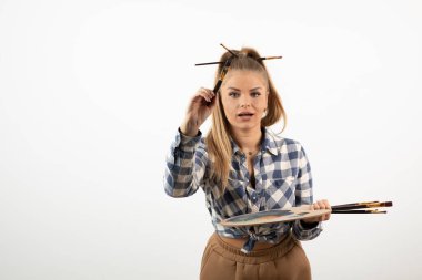 Genç sarışın ressam kız tahta paletle fırça çiziyor. Yüksek kalite fotoğraf