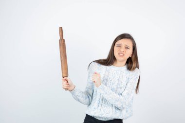 Beyaz arka planda paten iğnesi olan süveter giyen kız