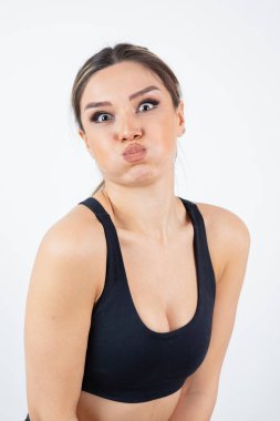 Siyah ekin giymiş, ayakta duran ve nefesini tutan formda genç bir kadın görüntüsü. Yüksek kalite fotoğraf