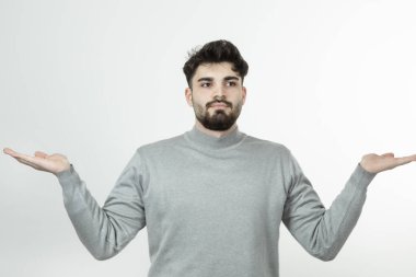 Gri kazaklı yakışıklı adam ayakta ve poz veriyor. Yüksek kalite fotoğraf