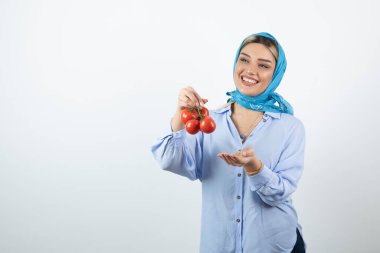 Mavi şallı güzel bir kadın elinde kırmızı taze domates tutuyor. Yüksek kalite fotoğraf