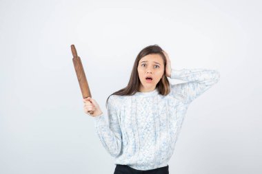 Beyaz arka planda paten iğnesi olan süveter giyen kız