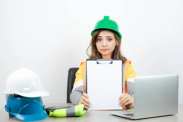 Arbeiterinnen Uniform Sitzen Schreibtisch Mit Laptop Und Klemmbrett Hochwertiges Foto — Stockfoto