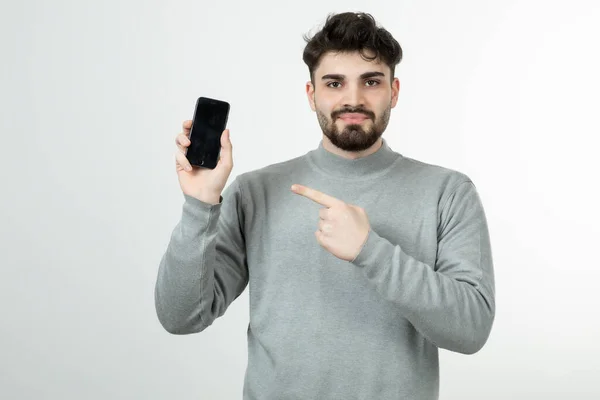 Portret Atrakcyjnego Faceta Celującego Smartfonem Białą Ścianę Wysokiej Jakości Zdjęcie — Zdjęcie stockowe