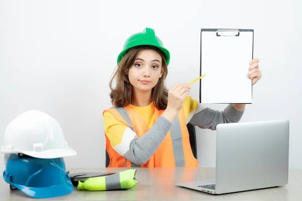 Arbeiterinnen Uniform Sitzen Schreibtisch Mit Laptop Und Klemmbrett Hochwertiges Foto — Stockfoto