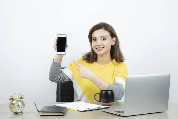 Masada Oturan Cep Telefonunu Işaret Eden Kadın Ofis Çalışanının Fotoğrafı — Stok fotoğraf