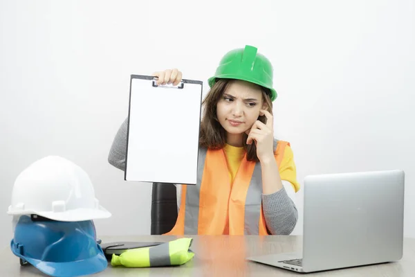 Arbeiterinnen Uniform Sitzen Schreibtisch Mit Laptop Und Klemmbrett Hochwertiges Foto — Stockfoto