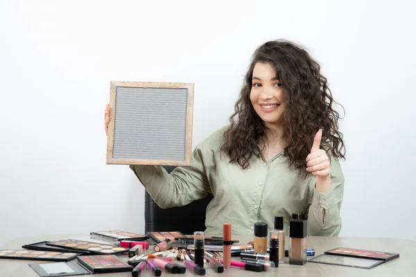 Mujer Joven Sentada Escritorio Con Personal Maquillaje Mostrando Pulgar Hacia — Foto de Stock