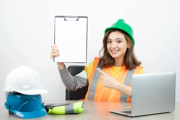 Arbeiterinnen Uniform Sitzen Schreibtisch Mit Laptop Und Klemmbrett Hochwertiges Foto — Stockfoto