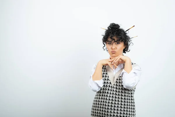 Photo of young woman with messy bun posing to camera. High quality photo