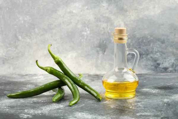 Groene Chili Pepers Met Een Glazen Fles Olie Een Marmeren — Stockfoto