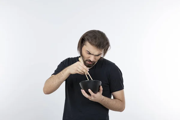 一个留着胡子的男人拿着碗 拿着筷子穿过白墙的图片 高质量的照片 — 图库照片