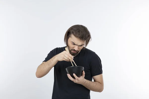 Imagem Homem Barbudo Segurando Tigela Com Pauzinhos Sobre Uma Parede — Fotografia de Stock