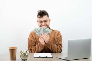 Genç ve mutlu muhasebeci masasında oturup paraları sayıyor. Yüksek kalite fotoğraf