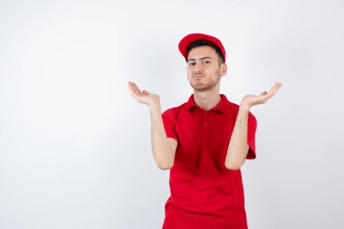 Beyazın üzerinde duran kırmızı üniformalı bir teslimatçı resmi. Yüksek kalite fotoğraf