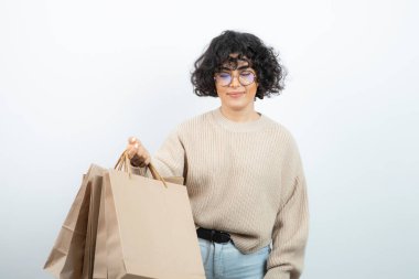 Esmer bir kadının gözlüklü hali. Elinde el işi çantaları var. Yüksek kalite fotoğraf