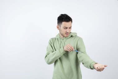 Beyazın üstüne şırınga enjekte eden genç bir adam görüntüsü. Yüksek kalite fotoğraf