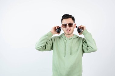 Gözlüklü yakışıklı bir adamın kulaklıkla poz verişi. Yüksek kalite fotoğraf