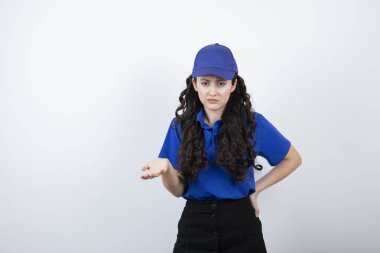 Mavi üniformalı genç bir teslimatçı avuç içini açmış. Yüksek kalite fotoğraf