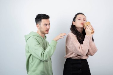 Esmer adam, genç kadın modelden bir fincan kahve alıyor. Yüksek kalite fotoğraf