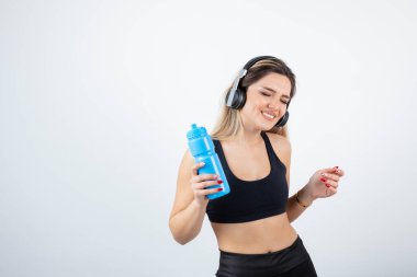  Şişeli kulaklıklı genç bir kadın.