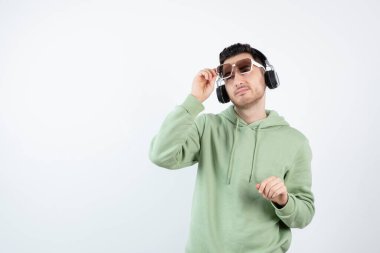 Kapüşonlu genç adamın portresi kulaklıkla müzik dinliyor. Yüksek kalite fotoğraf