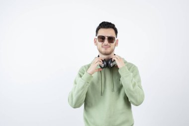 Gözlüklü yakışıklı bir adamın kulaklıkla poz verişi. Yüksek kalite fotoğraf