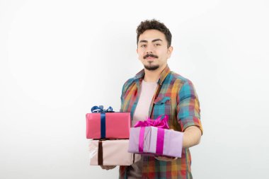 Çekici bir adamın portresi hediye kutuları veriyor ve kameraya bakıyor. Yüksek kalite fotoğraf