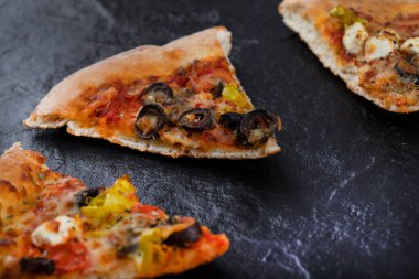 Lezzetli pizza parçaları siyah arka planda. Yüksek kalite fotoğraf