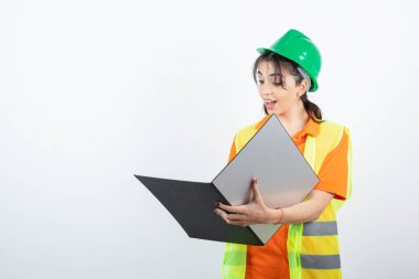 Koruyucu miğferli kadın mühendis ve sarı yelek klasörü. Yüksek kalite fotoğraf