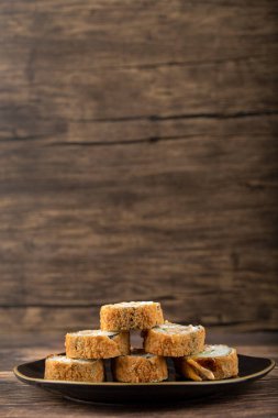 Siyah suşi ruloları ahşap bir masanın üzerine yerleştirilmiş. Yüksek kalite fotoğraf