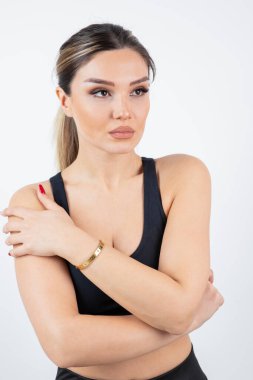 Siyah spor elbiseli sarışın kadın beyaz bir duvarın üzerinde dikilip poz veriyor. Yüksek kalite fotoğraf