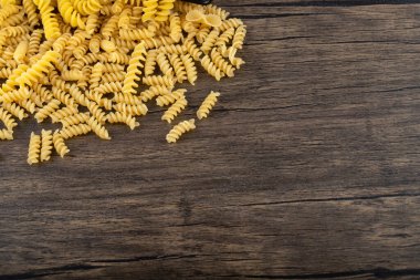 Tahta masaya saçılmış çiğ fusilli yığını. Yüksek kalite fotoğraf