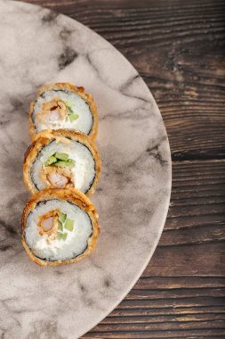 Ahşap bir masaya yerleştirilmiş mermer suşi ruloları. Yüksek kalite fotoğraf