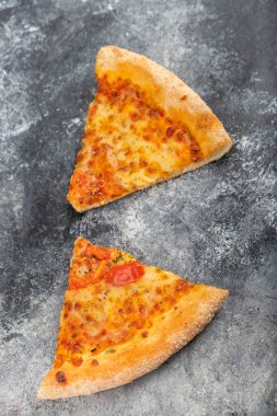 Taş zemine yerleştirilmiş iki dilim lezzetli peynirli pizza. Yüksek kalite fotoğraf