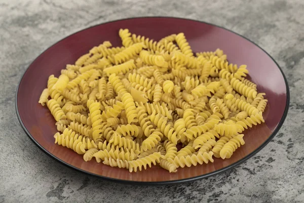 Assiette Rouge Pâtes Fusilli Crues Sur Table Pierre Photo Haute — Photo