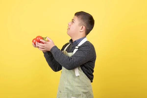 Ung Pojke Med Syndrom Förkläde Som Håller Tomater Högkvalitativt Foto — Stockfoto