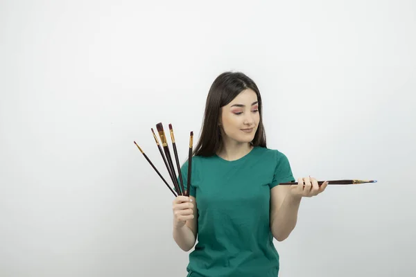 Retrato Joven Artista Sosteniendo Conjunto Pinceles Contra Pared Blanca Foto —  Fotos de Stock