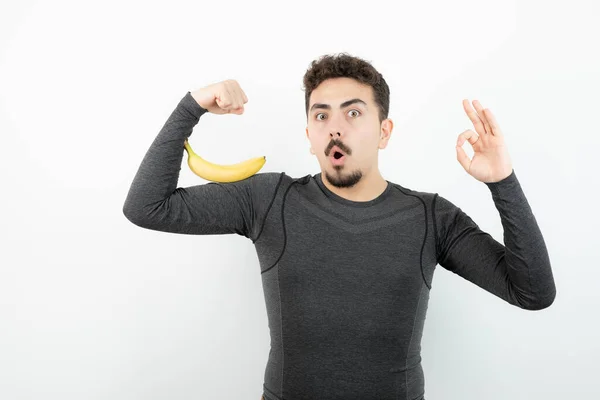 Jovem Bonitão Desportivo Segurando Banana Fazendo Sinal Foto Alta Qualidade — Fotografia de Stock