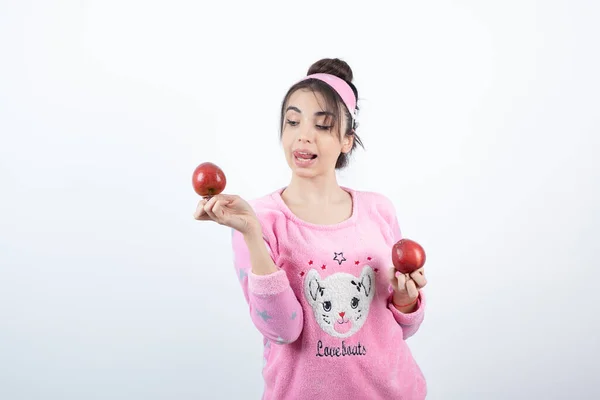 Foto Uma Jovem Pijama Segurando Duas Frutas Vermelhas Maçã Foto — Fotografia de Stock