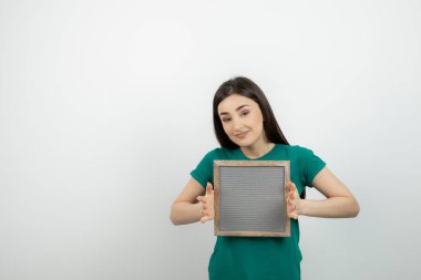 Beyaz duvarın karşısında el ele tutuşmuş güzel bir kadının portresi. Yüksek kalite fotoğraf