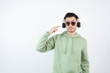 Kulaklıklı genç yakışıklı bir adamın beyazın üzerinde duruşu. Yüksek kalite fotoğraf