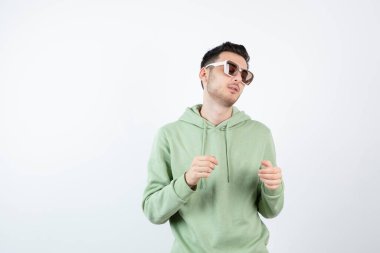 Gözlüklü yakışıklı bir adamın beyazın üzerinde poz verirken görüntüsü. Yüksek kalite fotoğraf