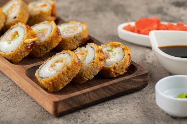 Wasabi, soya sosu ve taş bir masaya konmuş zencefil dilimli taze suşi ruloları. Yüksek kalite fotoğraf