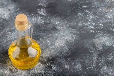 Taş bir masanın üzerine yerleştirilmiş cam bir şişe yağ. Yüksek kalite fotoğraf