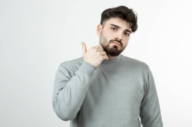 Kameraya poz veren gri kazaklı yakışıklı bir adam fotoğrafı. Yüksek kalite fotoğraf