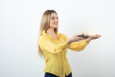 Beyaz şalgam tabağı olan sarışın bir kadın onları birine sunuyor. Yüksek kalite fotoğraf