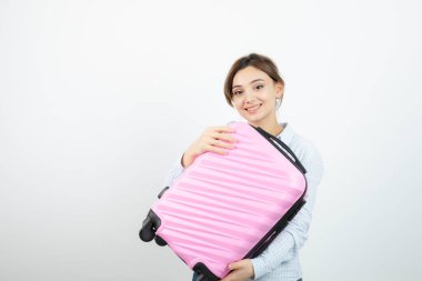 Kadın turist ayakta ve elinde pembe bir valiz tutuyor. Yüksek kalite fotoğraf